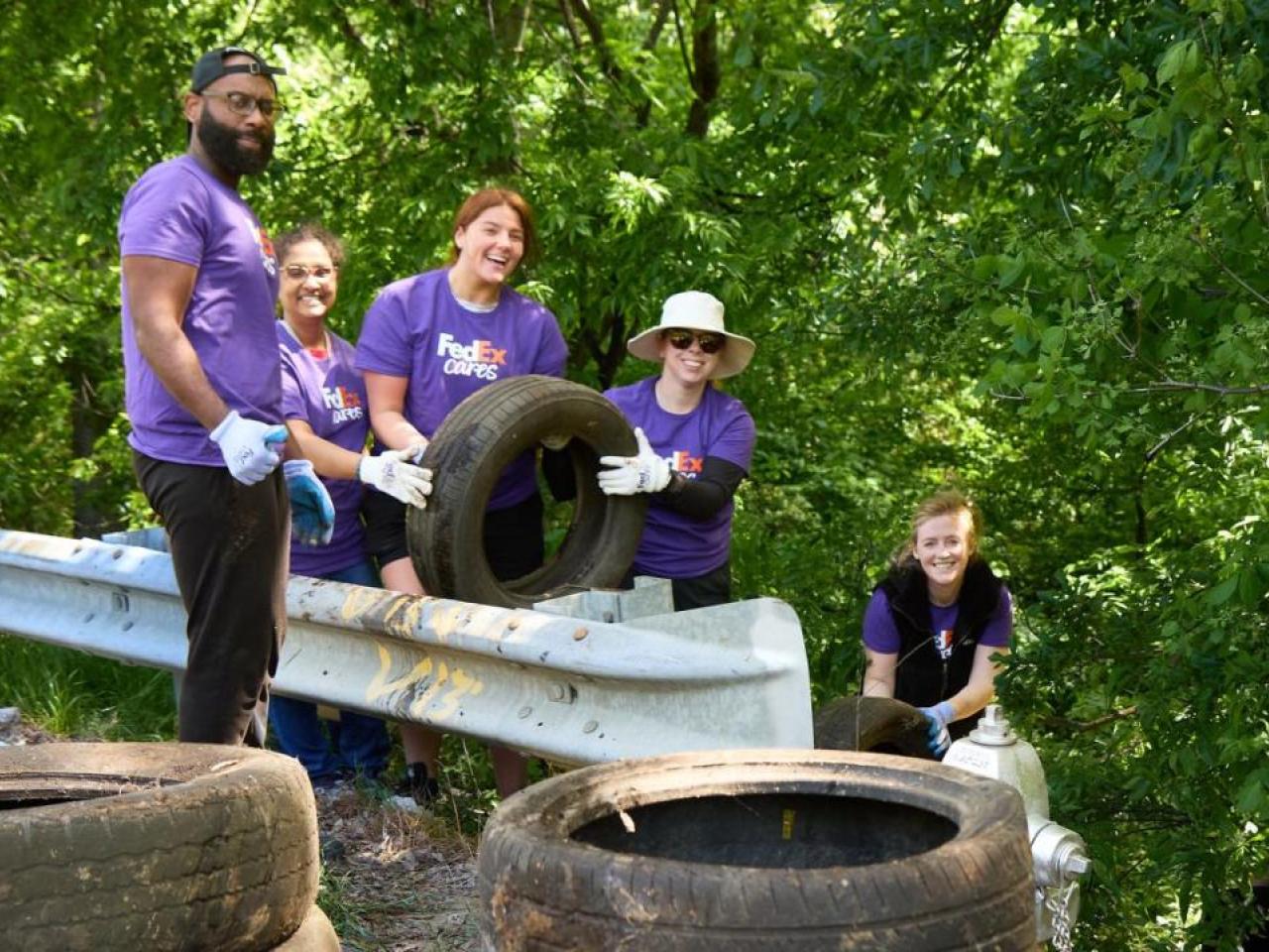 Volunteers pulling used tires out of the forested area.