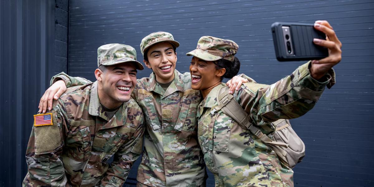 Three veterans with their arms around each other taking a photo