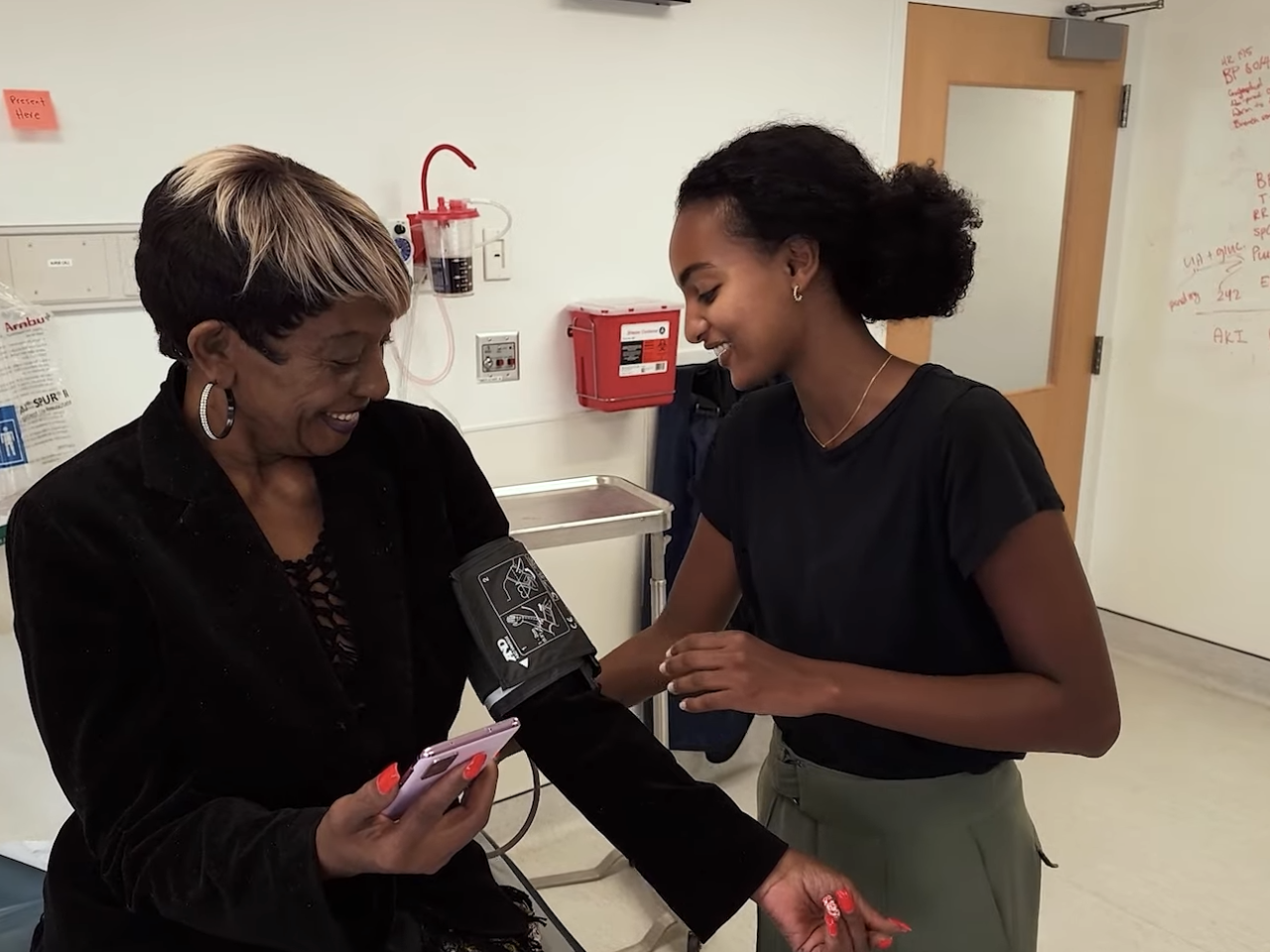 A person sat in a medical room getting their blood pressure taken