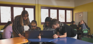 Students and a teacher in a classroom using laptop computers.